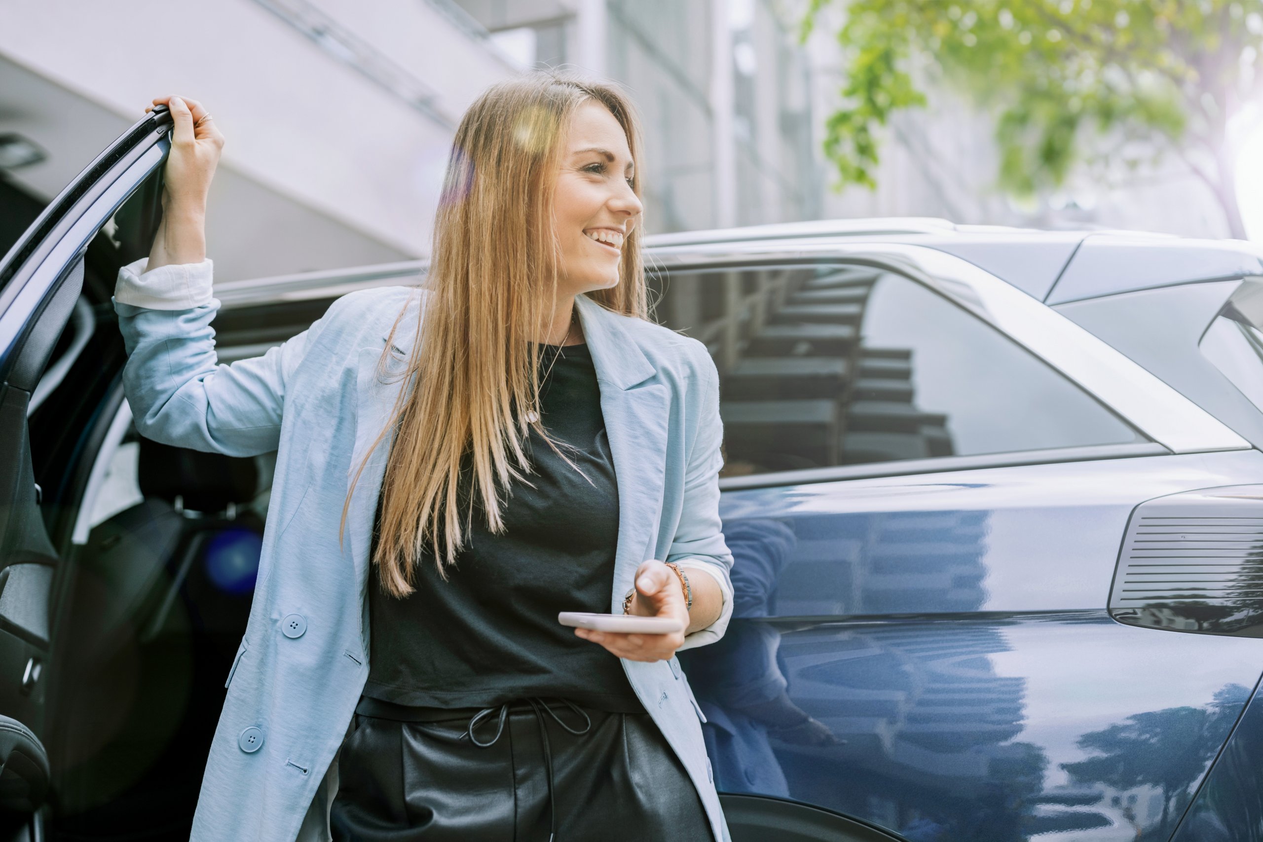 Glad kvinde i bymiljø bruger APCOA PARKING til nem og fleksibel parkering 